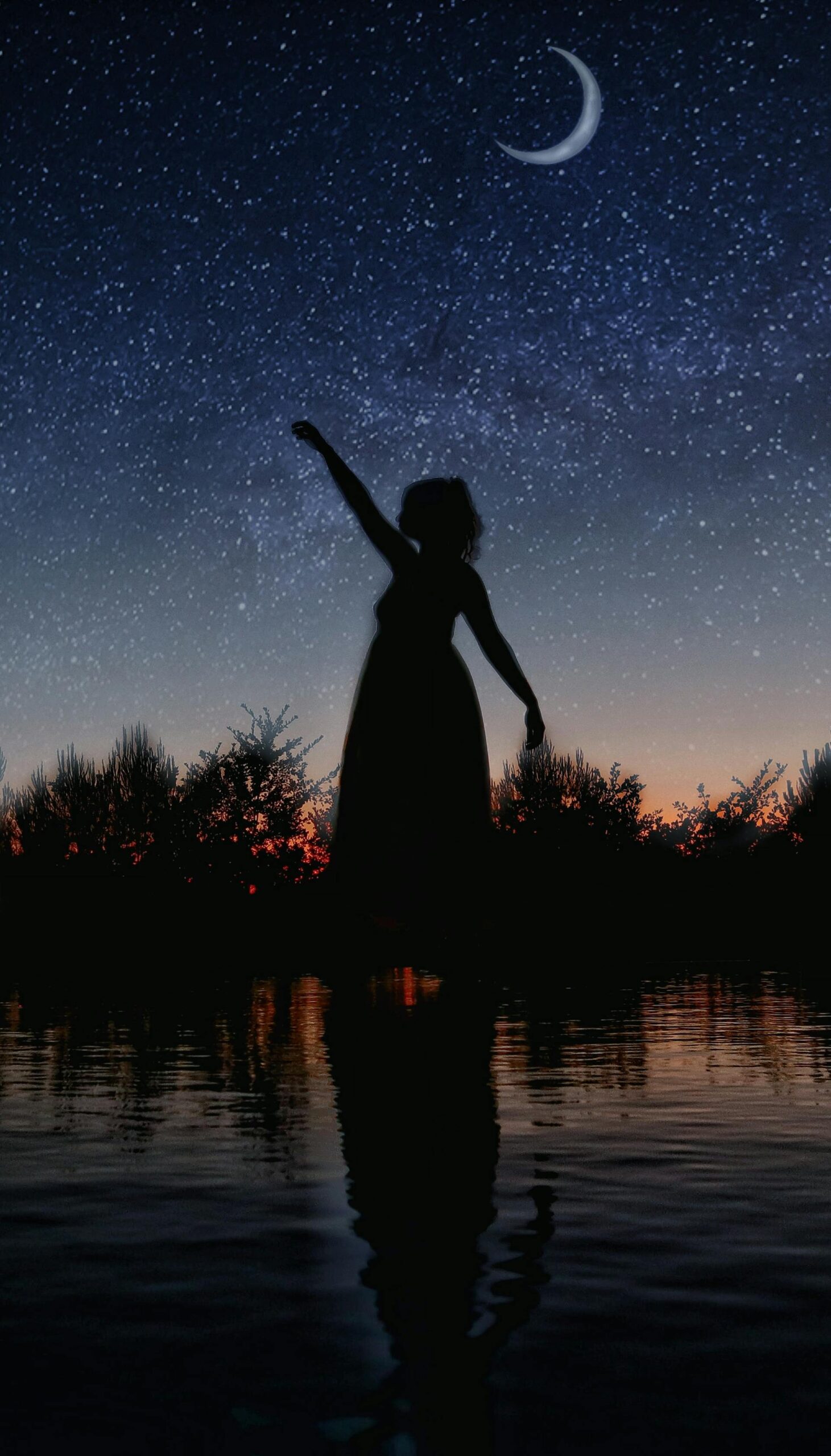 A woman in a field at night.